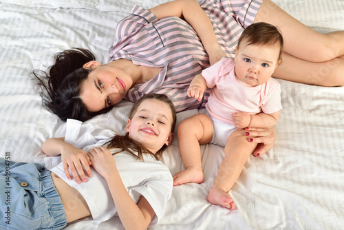 Mother and her daughters playing and smiling. Happy family.Home interior.