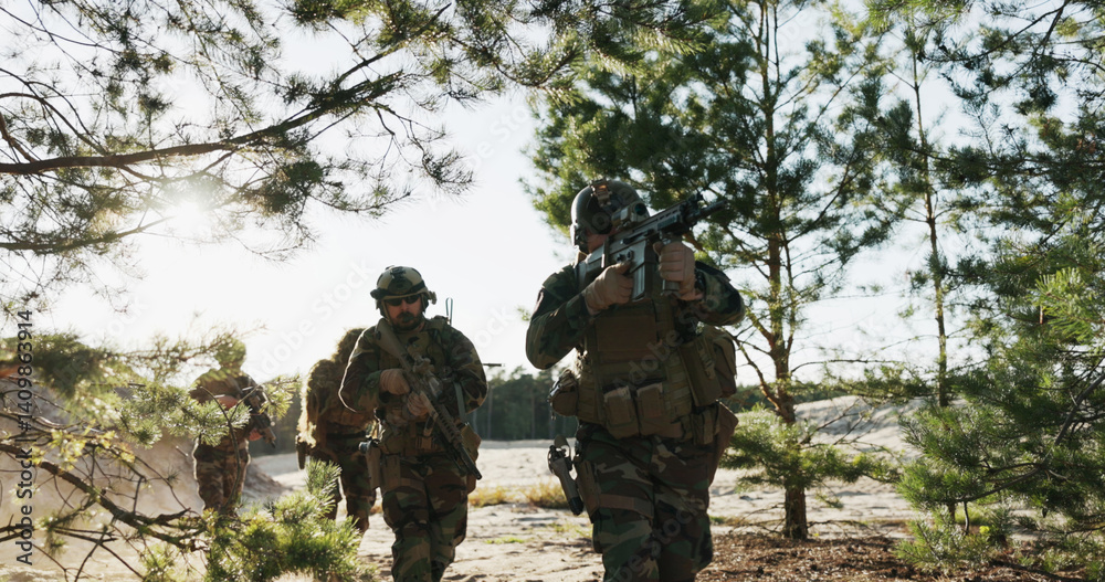 Fototapeta premium Shot from behind bushes, soldiers in camouflage uniforms aim their weapons, patrolling, monitoring the area, securing borders, and training on the firing range in a combat drill.