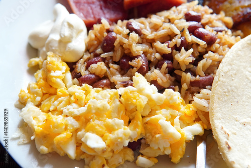 Traditional Costa Rican breakfast, rice and beans, called Gallo Pinto with eggs, tortilla, sausage and plantain.