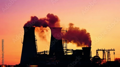 Silhouette of Industrial Complex at Sunset with Dark Smoke