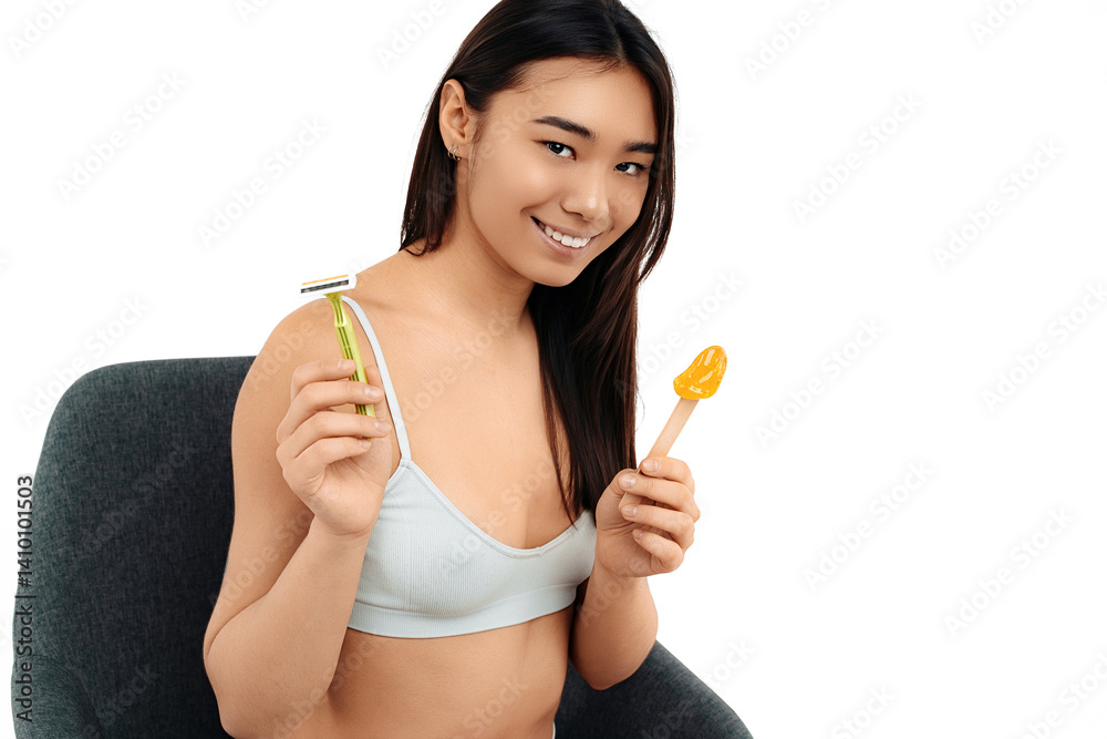 Positive asian young woman holding razor and stick with pasta for depilation Positive asian young woman holding razor and stick with pasta for depilation