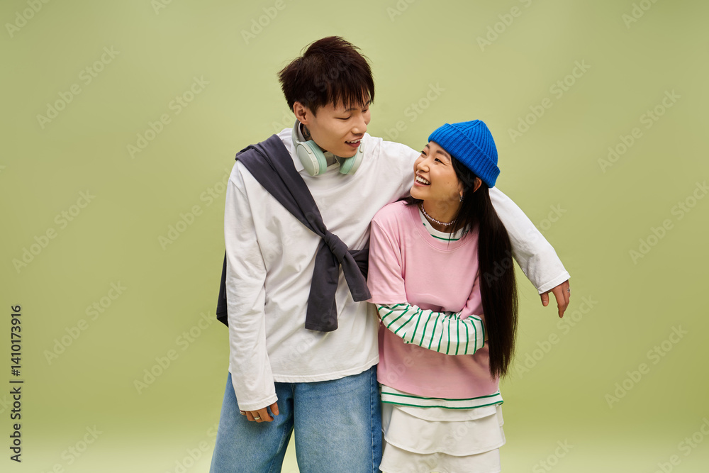 Obraz premium Charming couple shares joyful moments in stylish outfits against a soft green backdrop