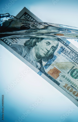 Obraz na płótnie Global economic and financial crisis. Close up US Dollar bills sinking in water as symbol of uncertain future of international trade and investment. Copy space. w salonie