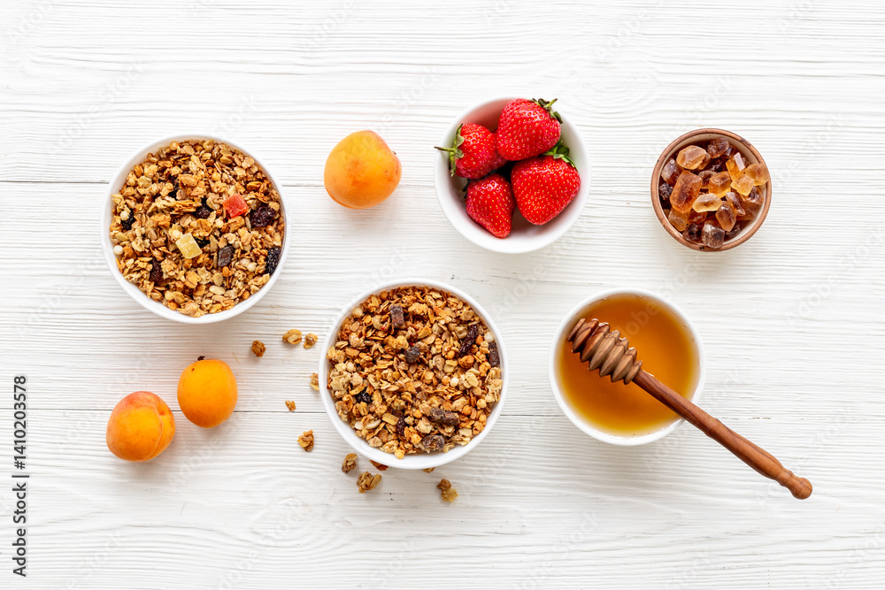 Fototapeta premium Flat lay of oatmeal granola and ingredients served on white table. Healthy breakfast