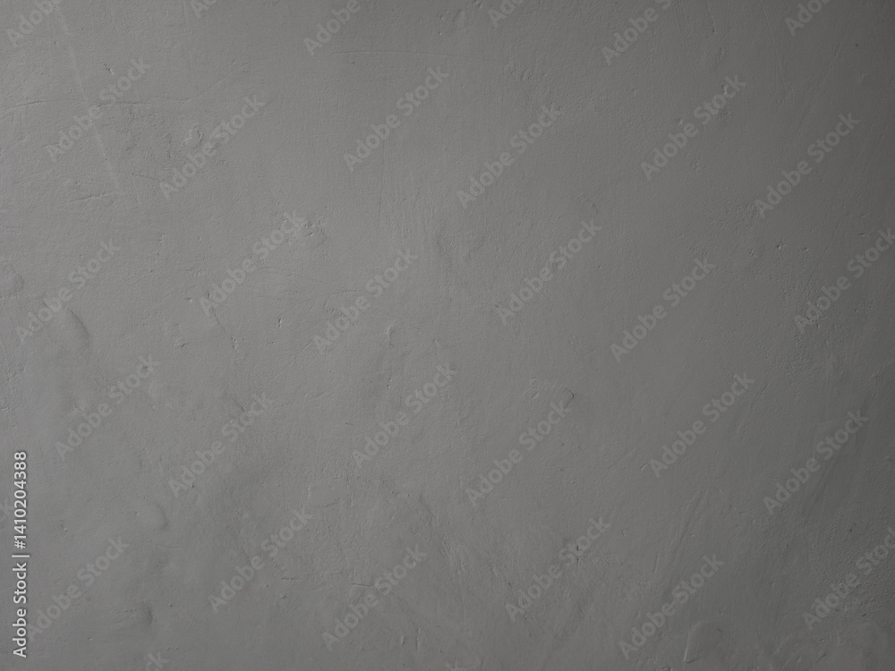 Textured dark gray plaster wall background. Uneven surface provides a neutral, minimalist backdrop. Textured dark gray plaster wall background. Uneven surface provides a neutral, minimalist backdrop.