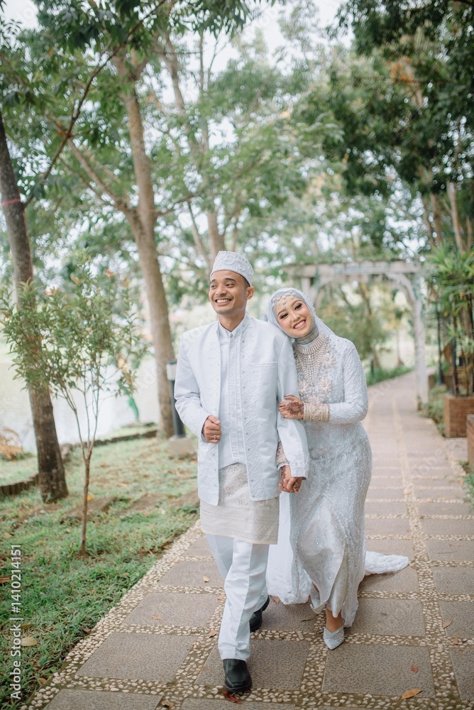 Muslim couple wearing elegant white wedding attire, walking together in a lush green garden. Perfect for prewedding, love, romance, and marriage celebration concepts.
Muslim couple wearing elegant white wedding attire, walking together in a lush green garden. Perfect for prewedding, love, romance, and marriage celebration concepts.