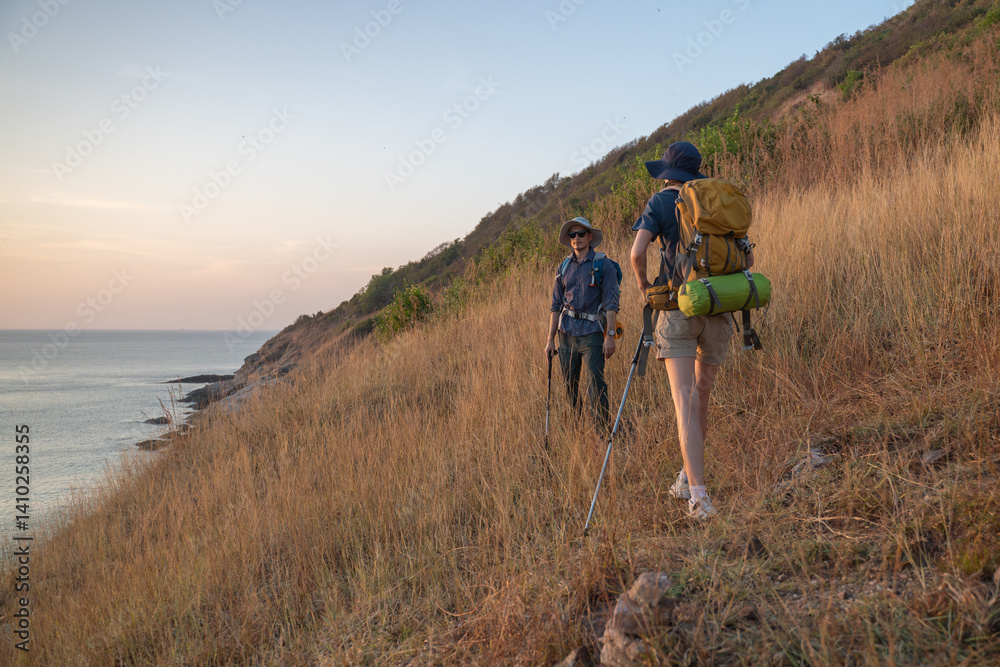 Obraz premium Hikers or explorers on journey carrying backpack, trekking poles looks into the distance observing and possibly guide trekking and trail exploration holiday ecotourism concept.