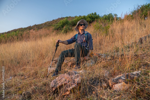Hikers or explorers on journey carrying backpack, trekking poles looks into the distance observing and possibly guide trekking and trail exploration holiday ecotourism concept.