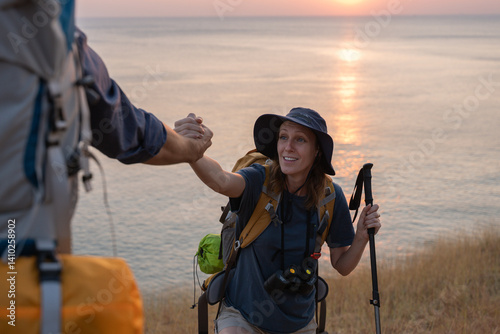 Hikers or explorers on journey carrying backpack, trekking poles looks into the distance observing and possibly guide trekking and trail exploration holiday ecotourism concept.