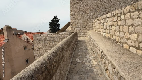 POV-style footage walking along the historic stone walls of Dubrovnik, Croatia. Captures the textures of the medieval architecture and panoramic views of the Adriatic backdrop