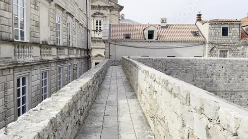 Perspective shot along the top of Dubrovnik’s city wall leading to a dome of the cathedral. A cinematic and peaceful look at the historic heart of the city