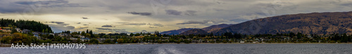 Obraz na płótnie Lake Wanaka, a summer cloudy afternoon with a mountain range and the town of Wanaka on the shore. South Island, New Zealand w salonie