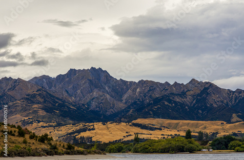 Obraz na płótnie Lake Wanaka, a summer cloudy afternoon with a mountain range and the town of Wanaka on the shore. South Island, New Zealand w salonie
