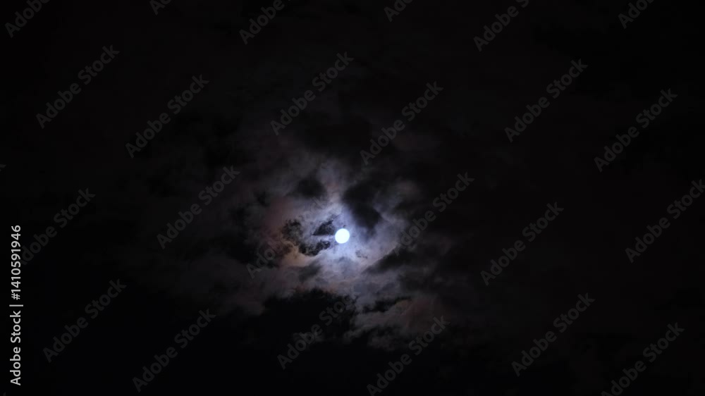 Clouds passing in front of the moon at night Clouds passing in front of the moon at night