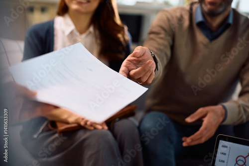 Close up of financial advisor offering contract to a couple during a meeting in the office.
