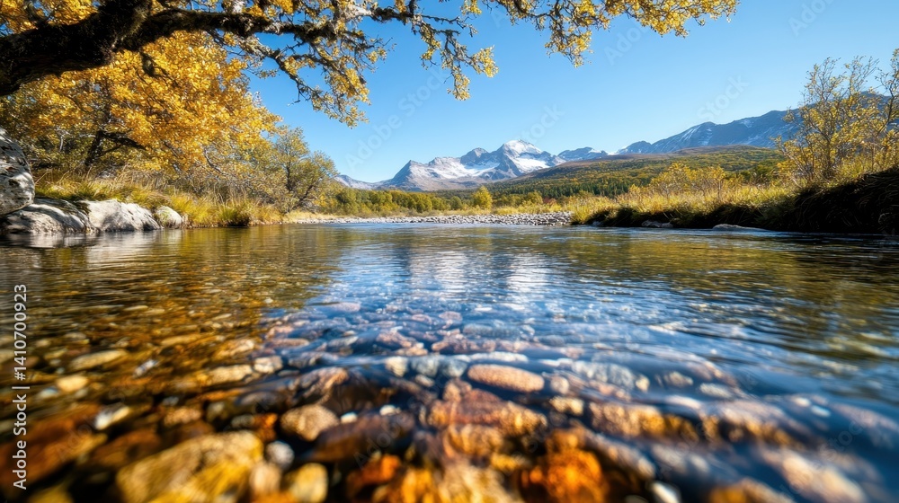 Obraz premium A tranquil river reflects the stunning autumn foliage and majestic mountains in this picturesque landscape, capturing the beauty of nature's seasonal transformation.