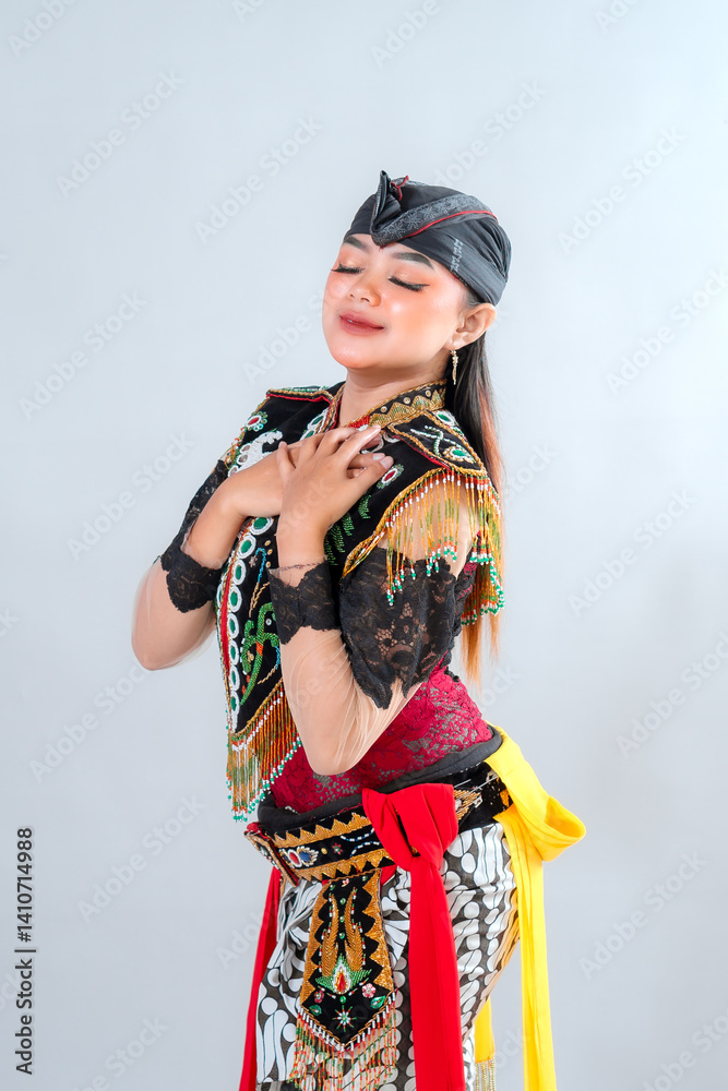 Fototapeta premium Beautiful Javanese dancer in traditional Jathilan costume expresses elegance and cultural pride with closed eyes and a graceful pose, reflecting Indonesia's rich heritage.