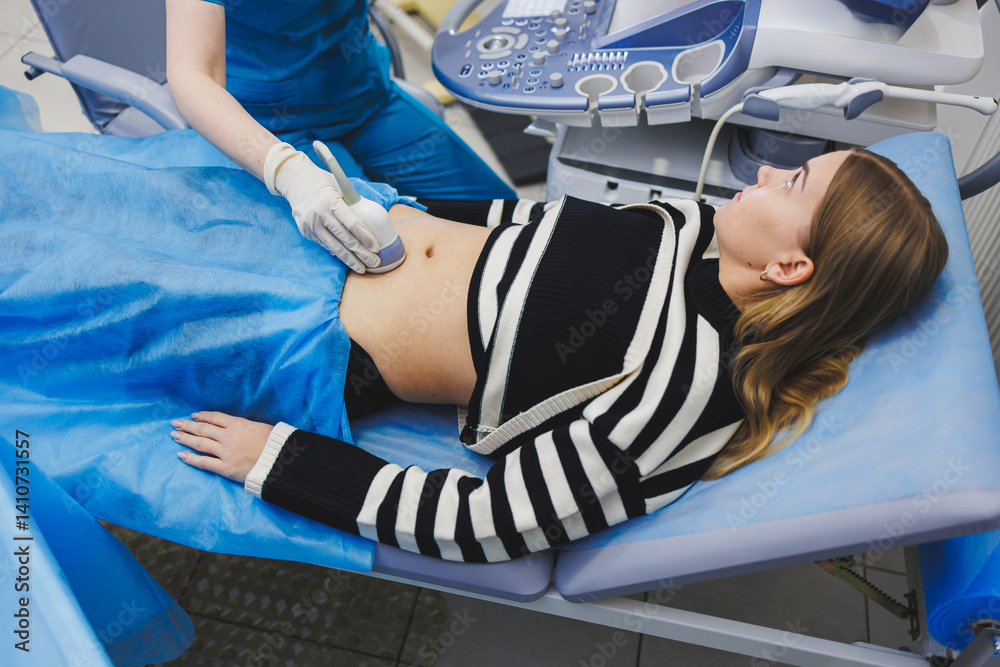 Ultrasound examination of the abdomen of a pregnant woman. Close-up of the abdomen of a pregnant woman. Checking the condition of the fetus using a sensor through the abdomen.