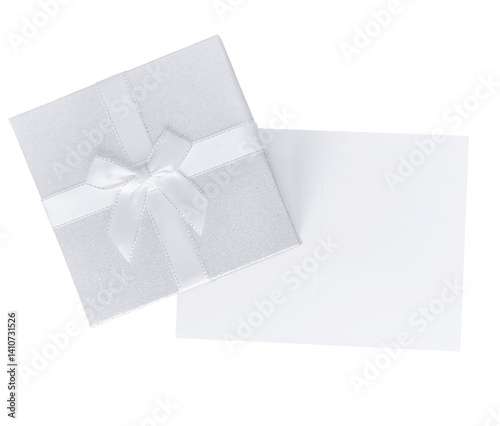 Top view of silver gift box with white ribbon and open greeting card, isolated on transparent background. Elegant festive composition with copy space.