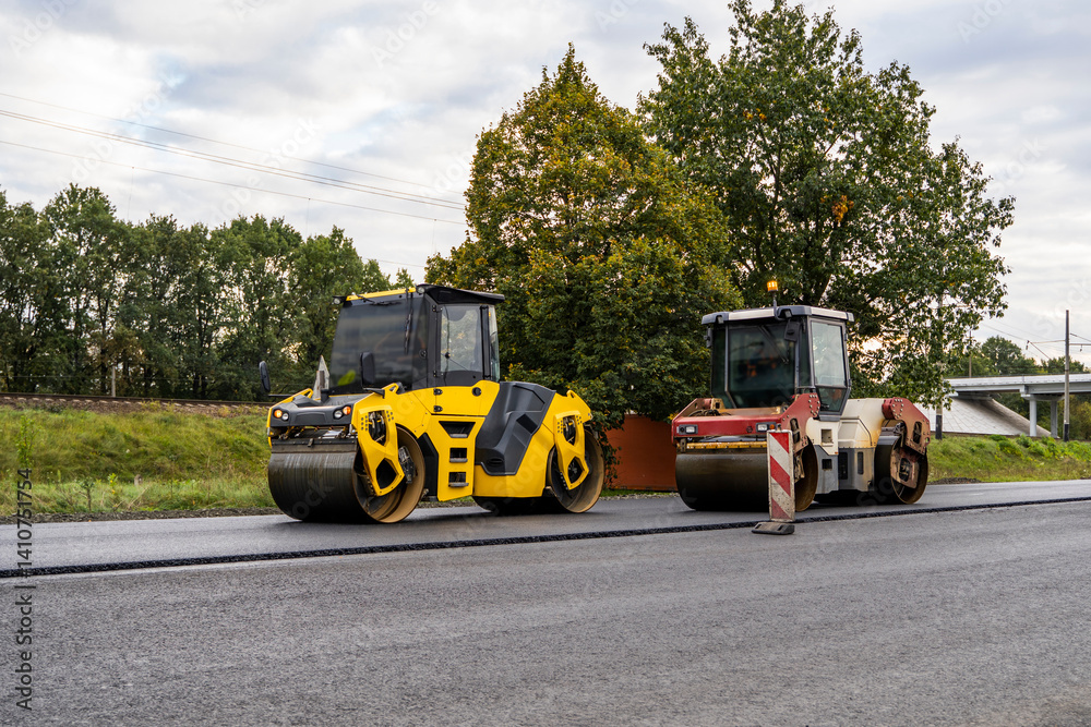 Two Heavy Asphalt Road Roller that press new hot asphalt on the roadway on a road construction site