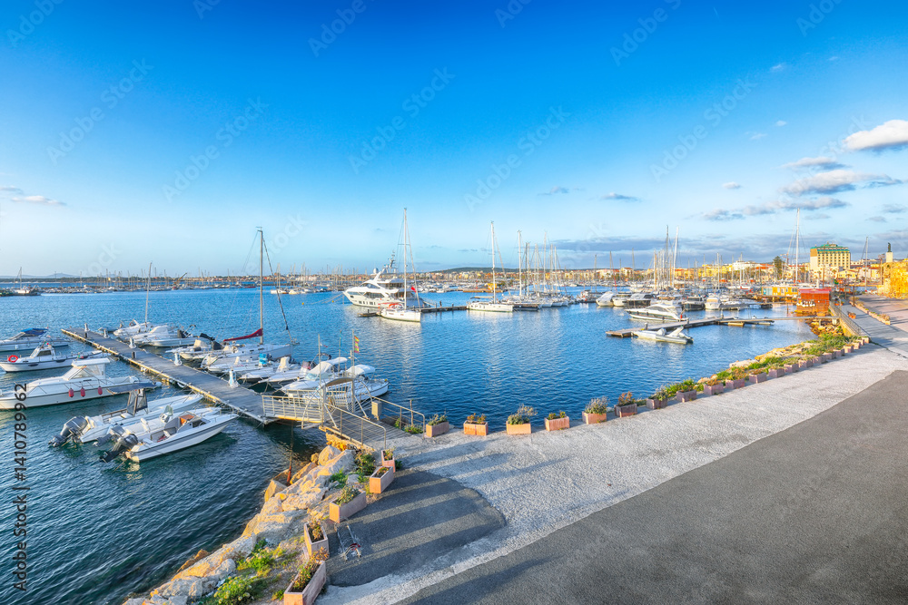 Unbelivable summer view of the Alghero Marina yacht port at the Gulf of Alghero with anchored sailboats.