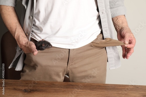 Εκτύπωση καμβά Senior man with rat in his pock near wooden table, closeup