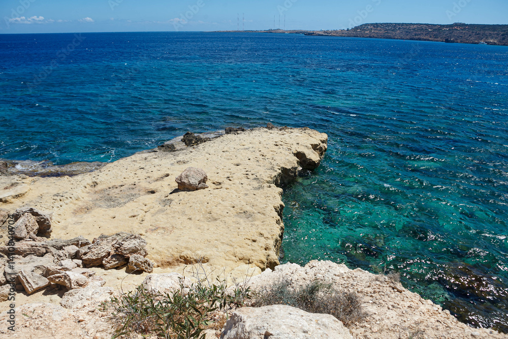 Visitors enjoy the vibrant beauty of Ayia Napas coastline, featuring crystal clear waters and sunlit rocky shores.