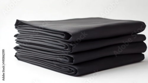 Obraz na płótnie A stack of neatly folded black fabric sheets, isolated on a white background for a minimalist touch. w salonie