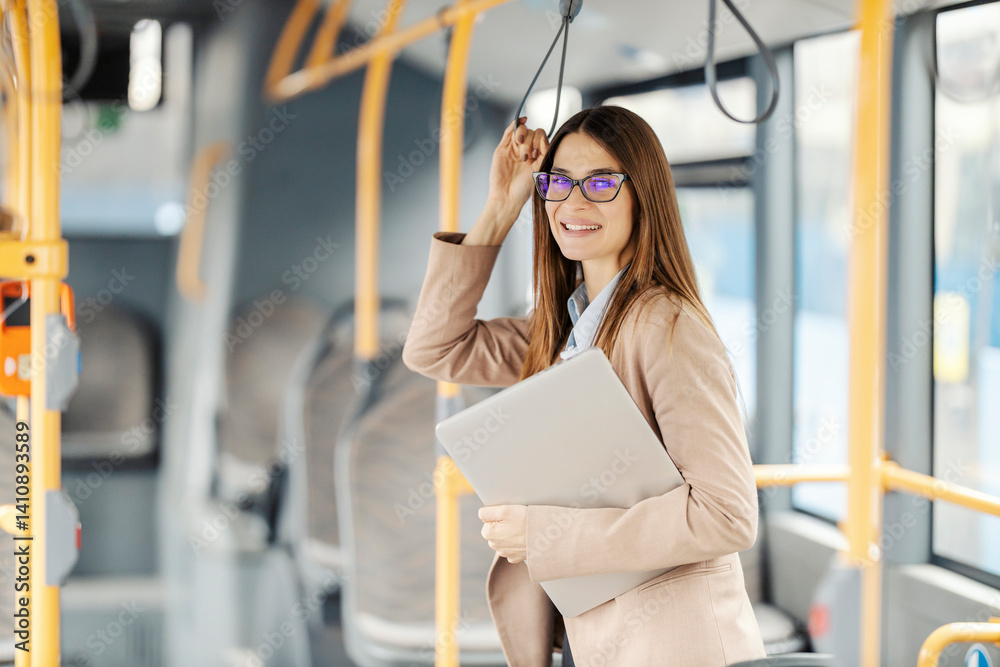 Portrait of fashionable young lady with laptop riding public city bus.