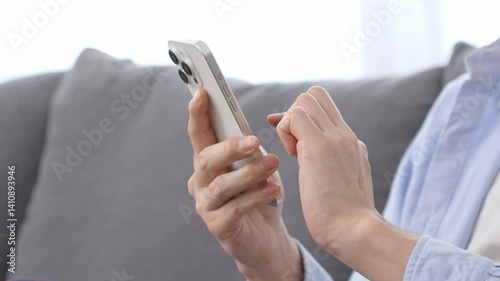 リビングでスマートフォンを使う男性の手元
