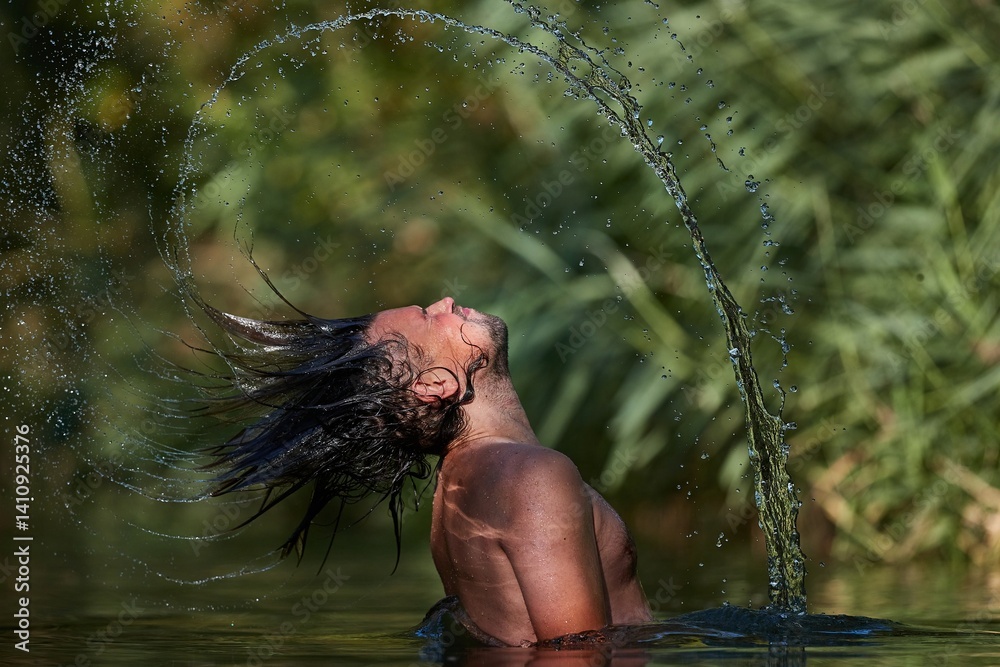 Man whipping wet hair in the lake