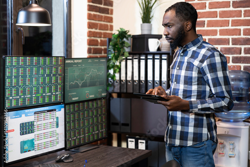 Εκτύπωση καμβά African american male investor standing with his tablet, monitoring forex charts on multiple screens