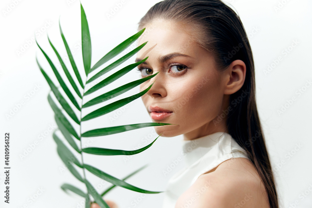 Close-up portrait of a young model with a palm leaf, showcasing natural beauty and elegance in a minimalistic style, ideal for fashion and beauty concepts. Close-up portrait of a young model with a palm leaf, showcasing natural beauty and elegance in a minimalistic style, ideal for fashion and beauty concepts.