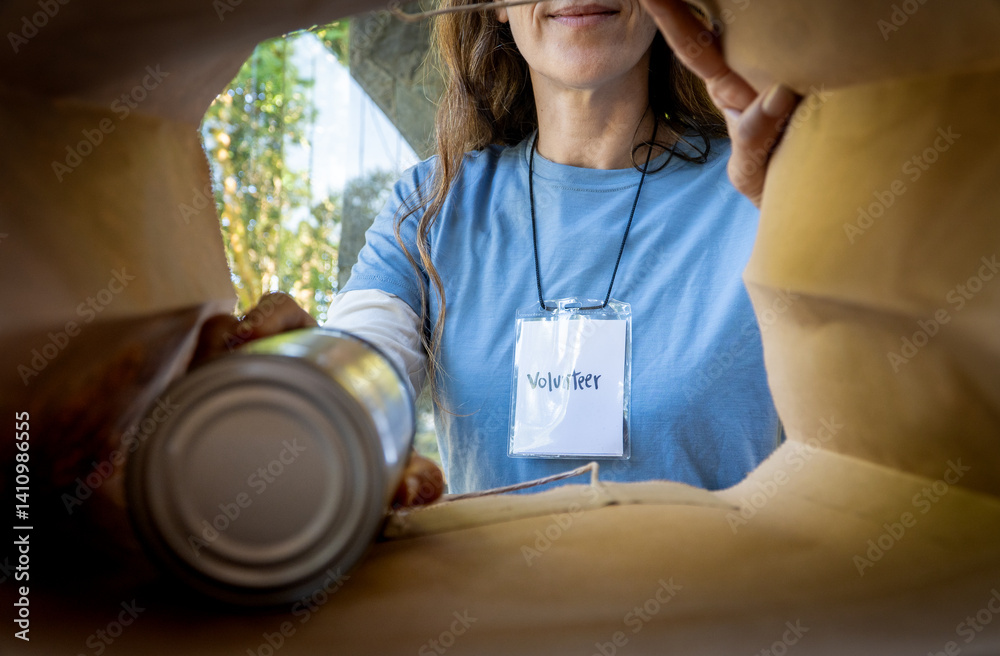 Smiling Female Volunteer Packing Canned Food for Donation