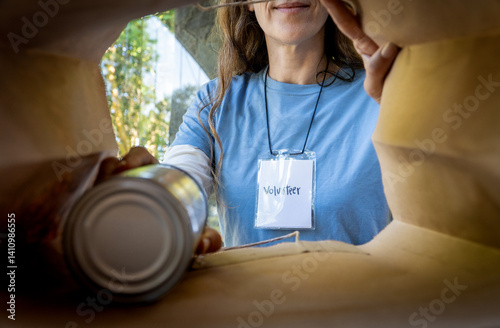 Obraz na płótnie Smiling Female Volunteer Packing Canned Food for Donation w salonie
