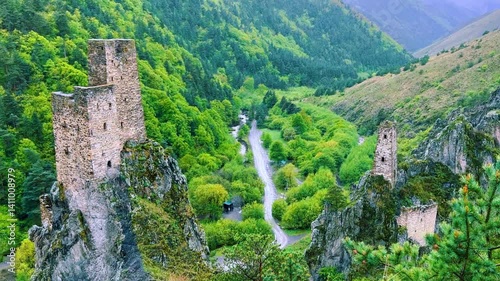The tower complex is located inside the green mountains. The Republic of Ingushetia, Russia. View of the defensive towers of Ingushetia in the North Caucasus on a cloudy day in spring. 4K