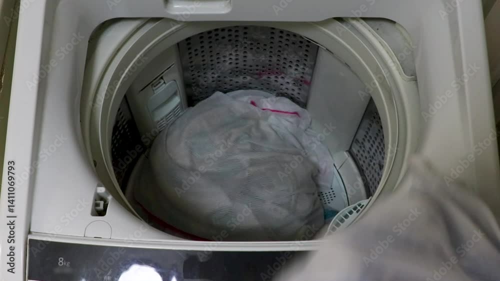 洗濯機から洗い終わった洗濯物を取り出す