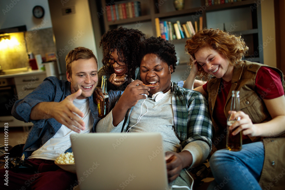 Young and diverse group of friends watching a movie on laptop in the living room on the couch