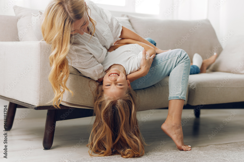 Mother and daughter enjoying quality time together on cozy living room couch