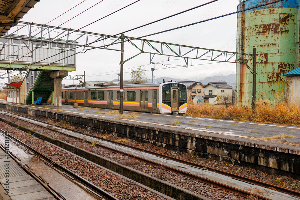 Naklejka premium JR上越線のローカル電車が入ってきた。 JR五日町駅。 寂れた雰囲気が良い感じ。 五日町の市街地の風景。 雪国特有の雰囲気がある。 晩秋なので各所で紅葉が見られる。 新潟県魚沼市 - 2024年11月30日 