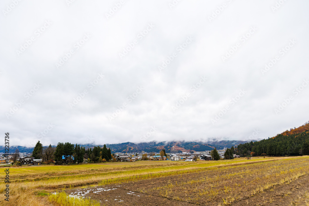 Fototapeta premium 新潟の山麓の紅葉と田園風景。雪国特有の雰囲気がある。 晩秋なので各所で紅葉が見られる。 新潟県魚沼市 - 2024年11月30日 