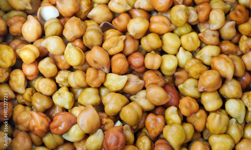 A small heap of brown chana on a pure white background. Dark brown, round, and slightly rough, with an earthy aroma and a nutty, hearty flavor.
