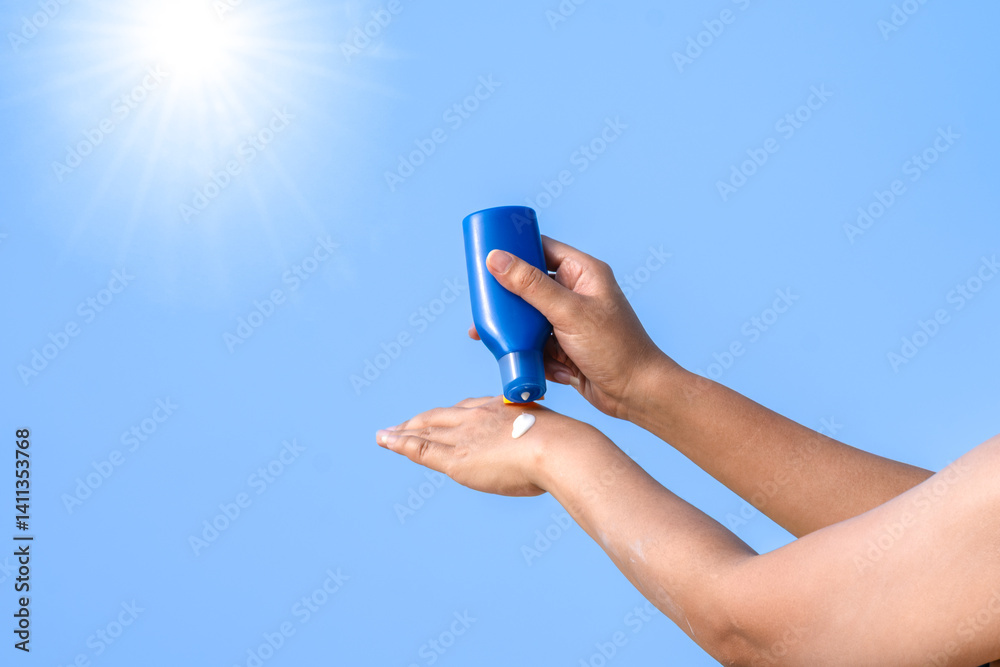 Hand of female holding sunscreen. Very sun light Sky background.Health concepts and skin care