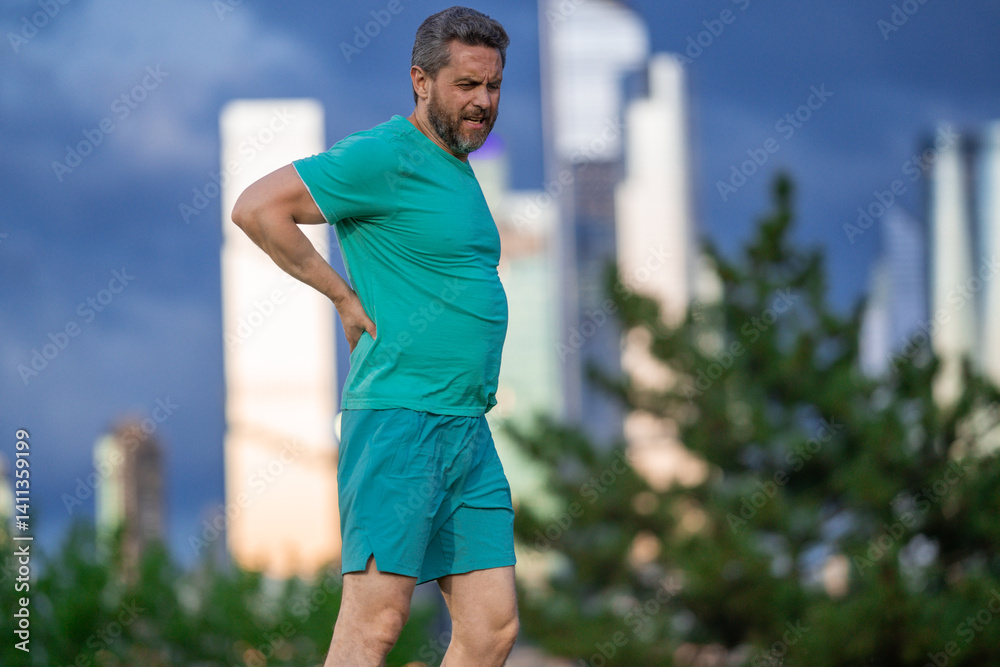 Mature sport man feeling back pain. Trouble with sore muscles. Sports-related back injury. Spine discomfort after running. Muscle tension after workout. Painful spasm in the back. Back pain.