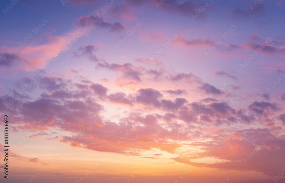 Fototapeta premium High-resolution image of a soft sunset sky with pastel pink, lavender, and gold tones. Gentle clouds and natural light glow. Dreamy and serene, suitable for beauty and wellness designs.