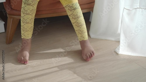 Child wearing yellow lace leggings seated at home