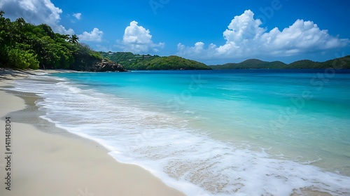 Sandy beach with turquoise waves gently rolling in, with a bright blue sky in the background