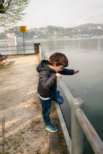 Child explores edge of lake in tranquil setting