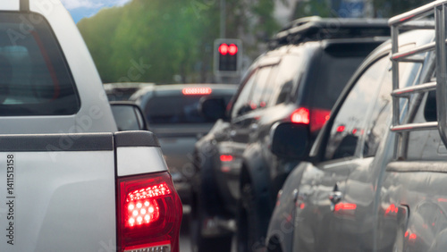 Rear side of pickup car with turn on brake light. Many cars are queuing up at a red traffic light.