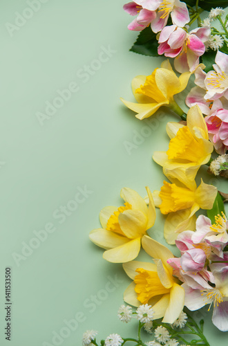 Daffodils and pink flowers creating a vibrant spring border on pastel green background